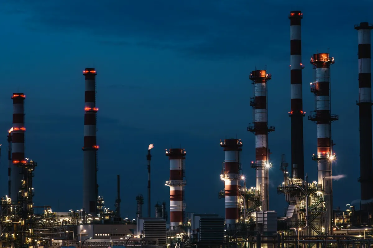 Industrial processing towers and pipework illuminated at dusk