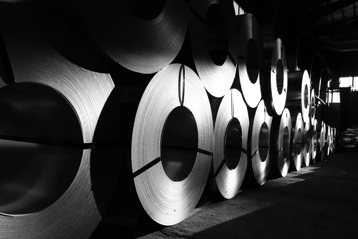 Coils of metal arranged in an industrial warehouse